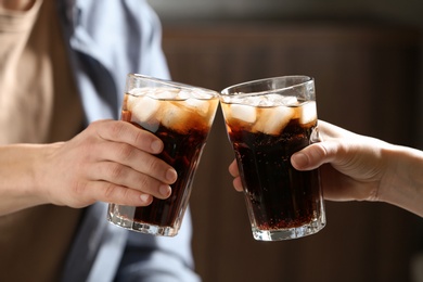 Photo of Couple with glasses of cold cola indoors, closeup