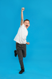Photo of Full length portrait of emotional preteen boy on blue background