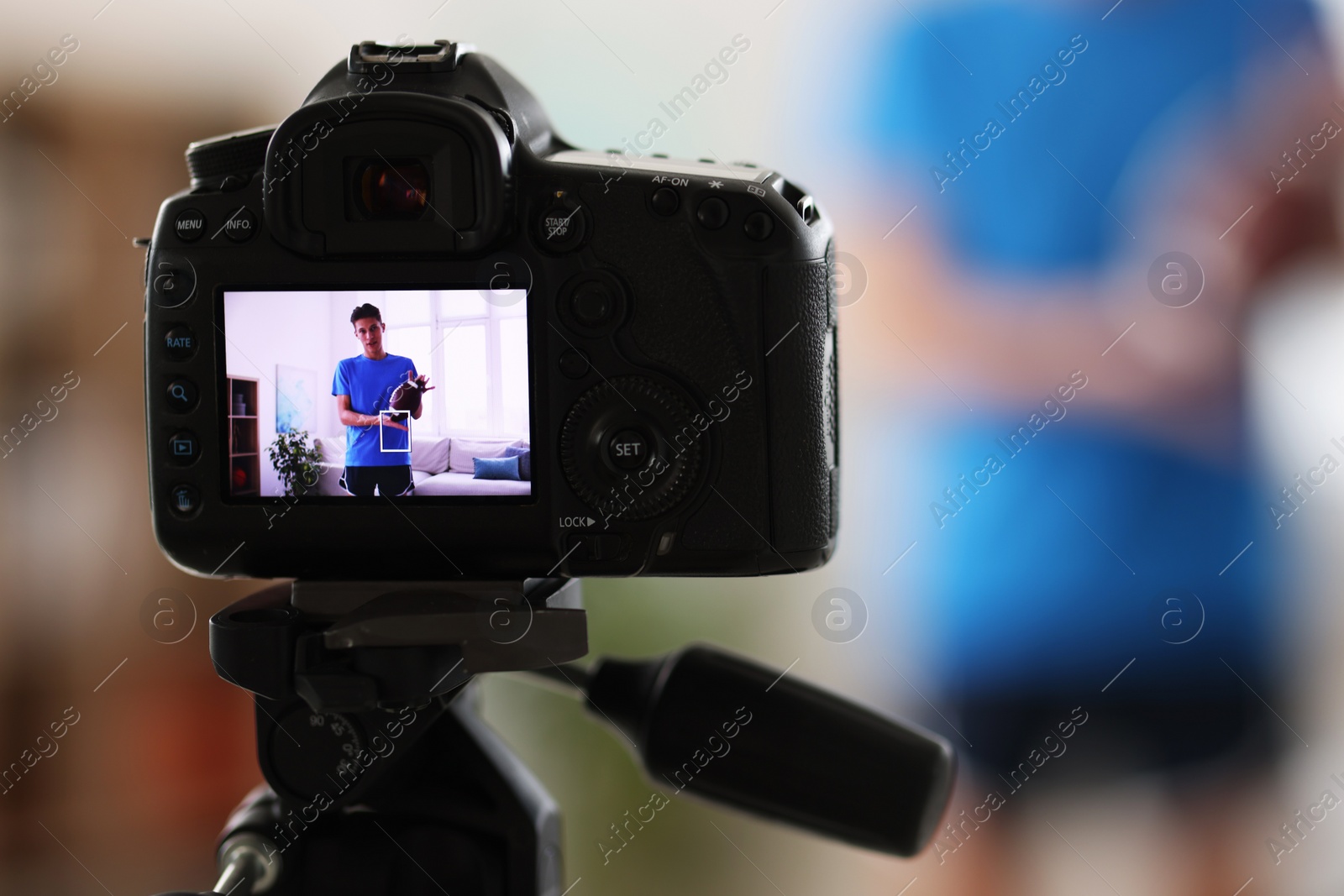 Photo of Sports blogger recording fitness lesson at home, focus on camera. Space for text
