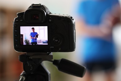 Sports blogger recording fitness lesson at home, focus on camera. Space for text