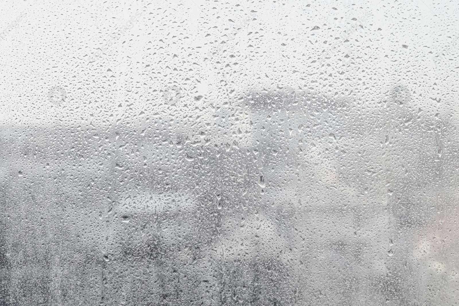 Photo of Blurred view of city from window on rainy day