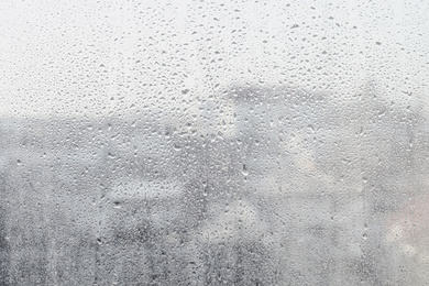 Photo of Blurred view of city from window on rainy day