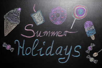 Photo of Inscription Summer Holidays and different drawings on blackboard. School break