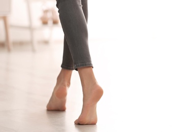 Photo of Young woman walking barefoot at home, closeup. Heating concept