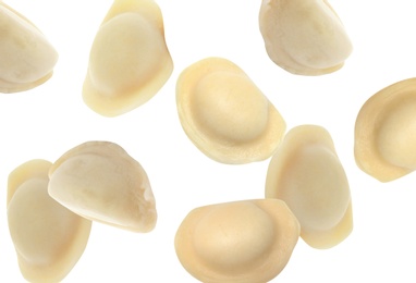 Image of Many tasty dumplings falling on white background