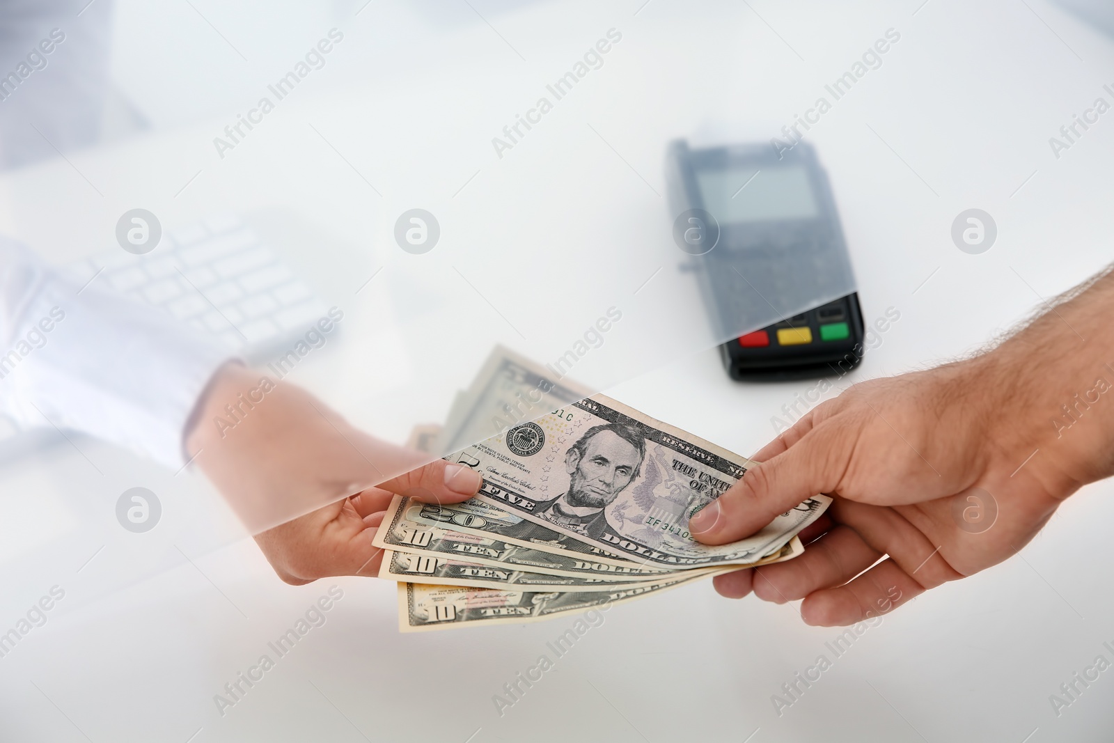 Photo of Man giving money to teller at cash department window, closeup