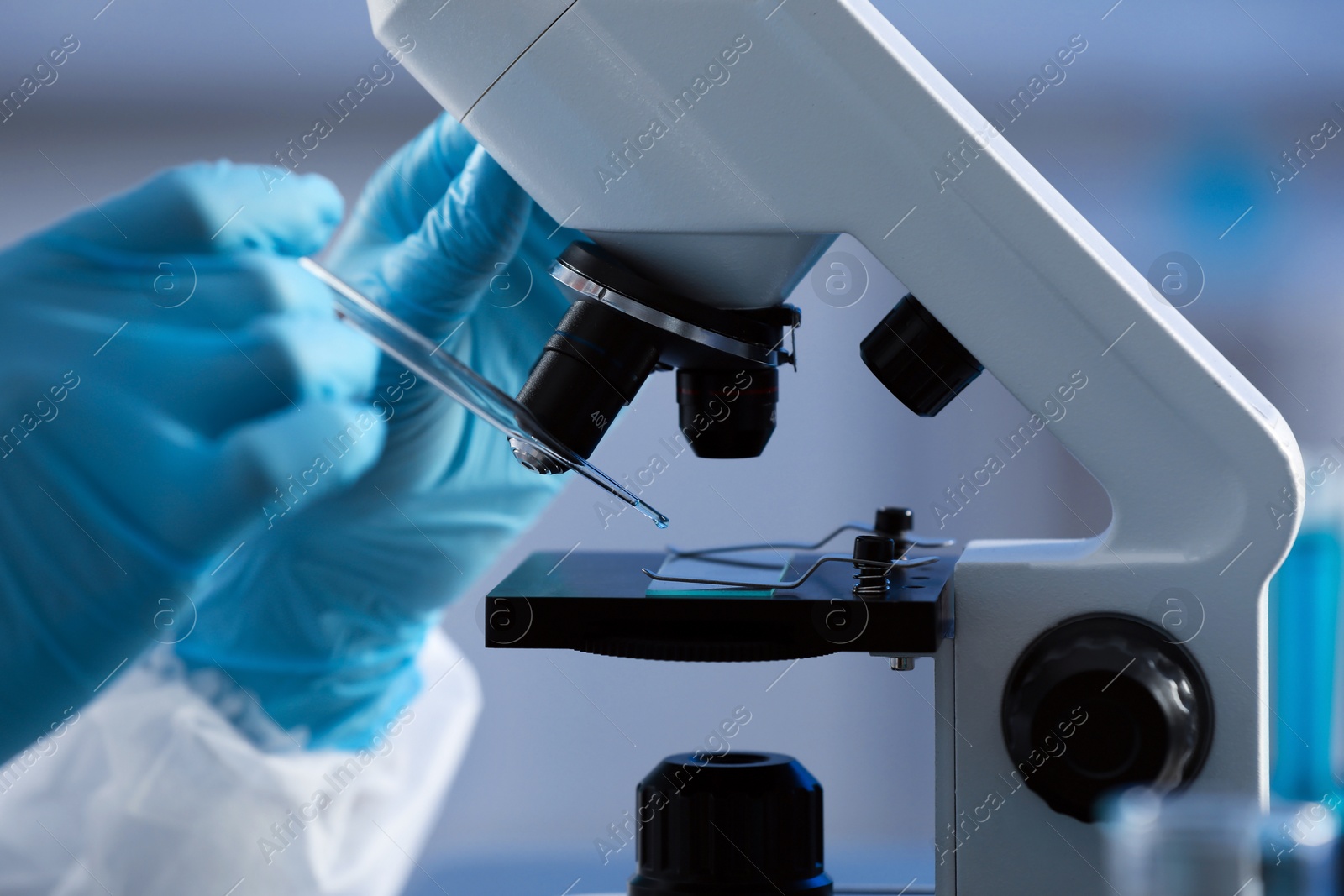 Photo of Scientist working with microscope on grey background, closeup