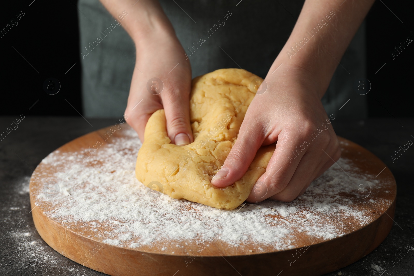 Photo of Making shortcrust pastry. Woman kneading dough at table, closeup