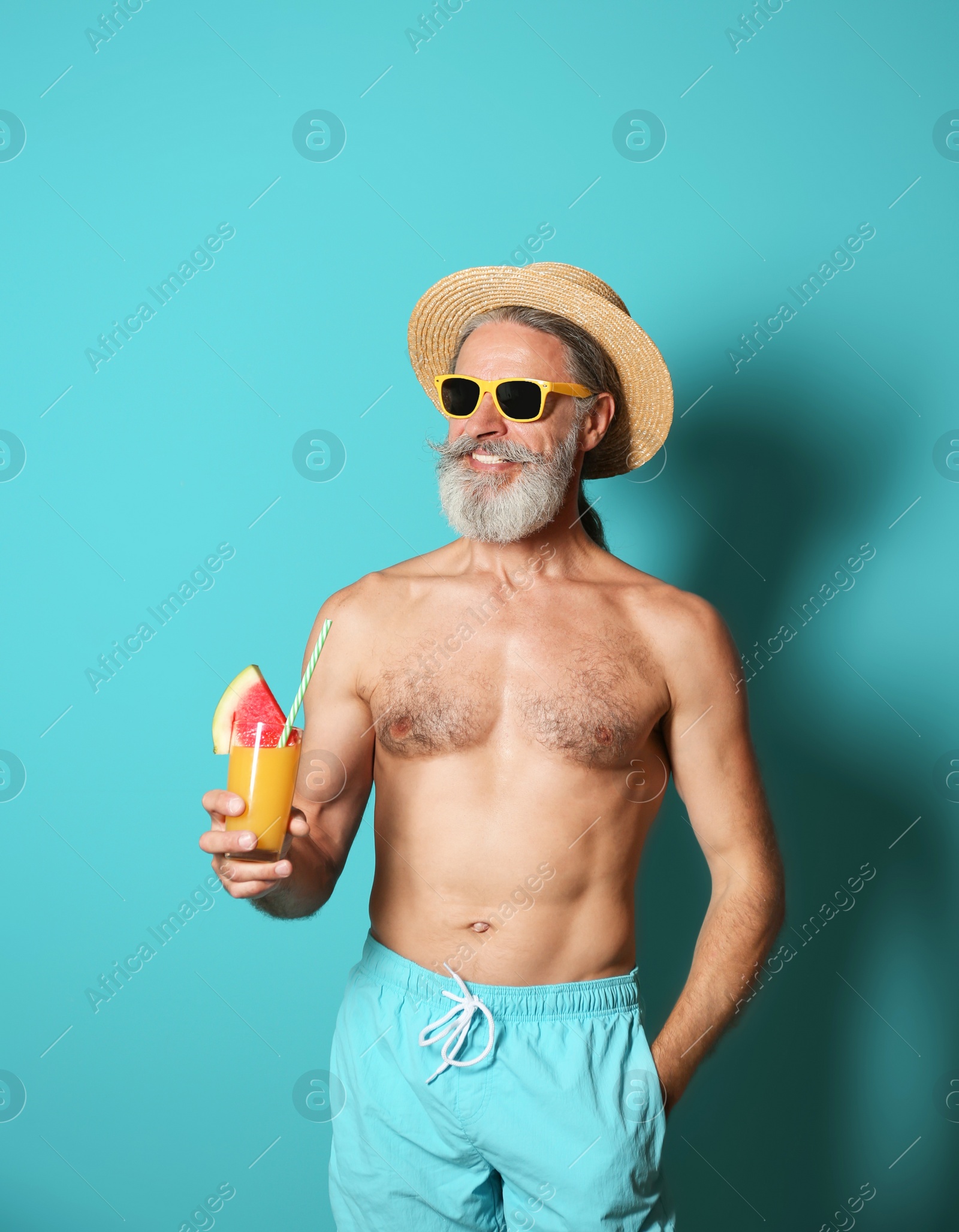 Photo of Shirtless man with glass of cocktail on color background