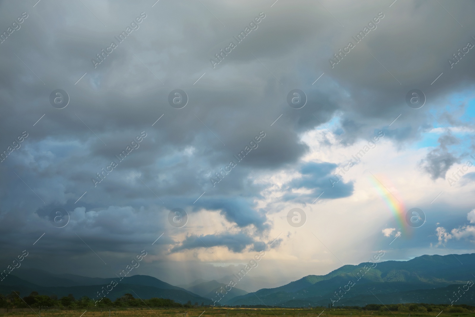 Photo of Picturesque view of green hills under clouds