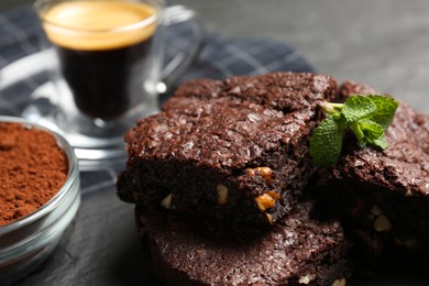 Photo of Delicious chocolate brownies with nuts and fresh mint on table, closeup