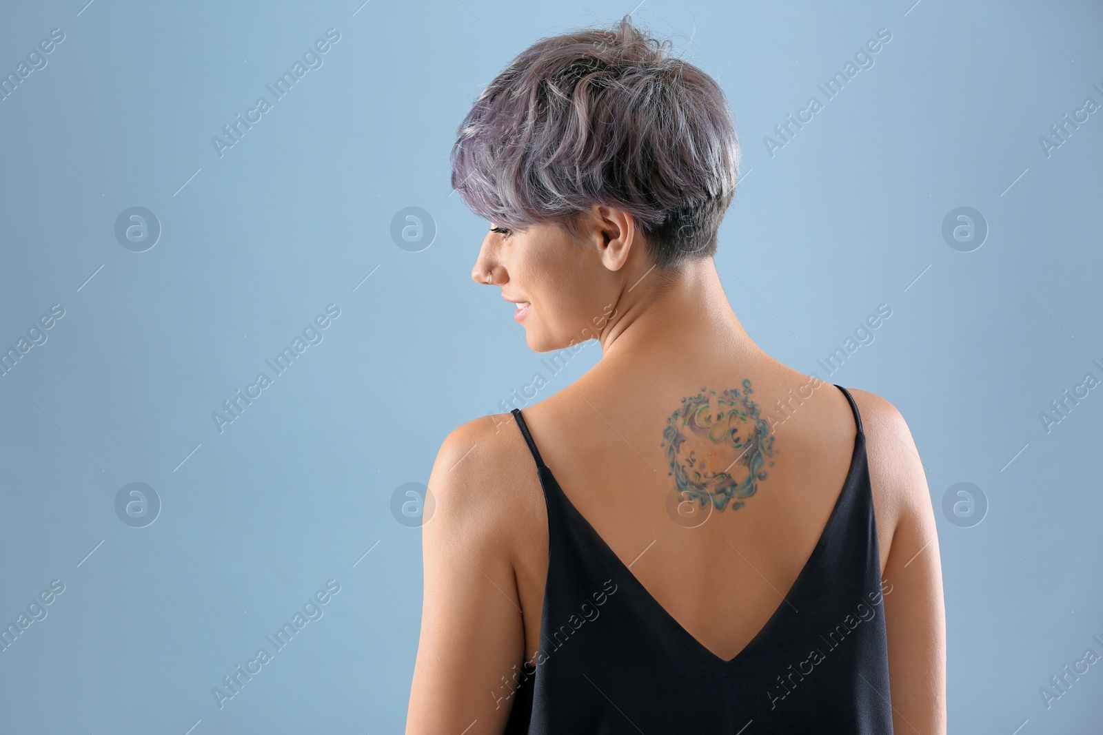 Photo of Young woman with tattoo on color background. Space for text