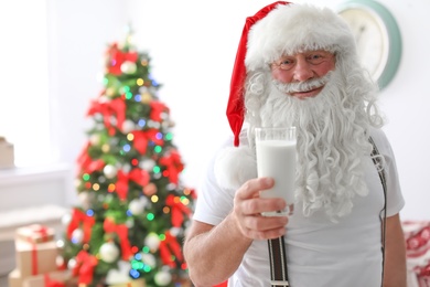 Authentic Santa Claus with glass of milk indoors