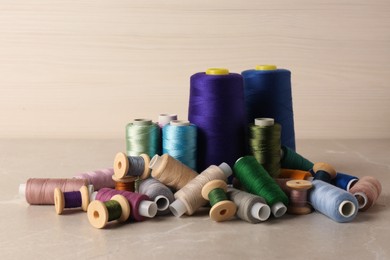 Photo of Set of color sewing threads on light grey table
