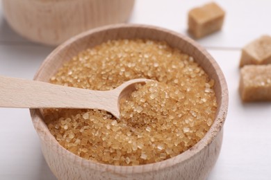 Photo of Bowl and spoon with brown sugar on table, closeup