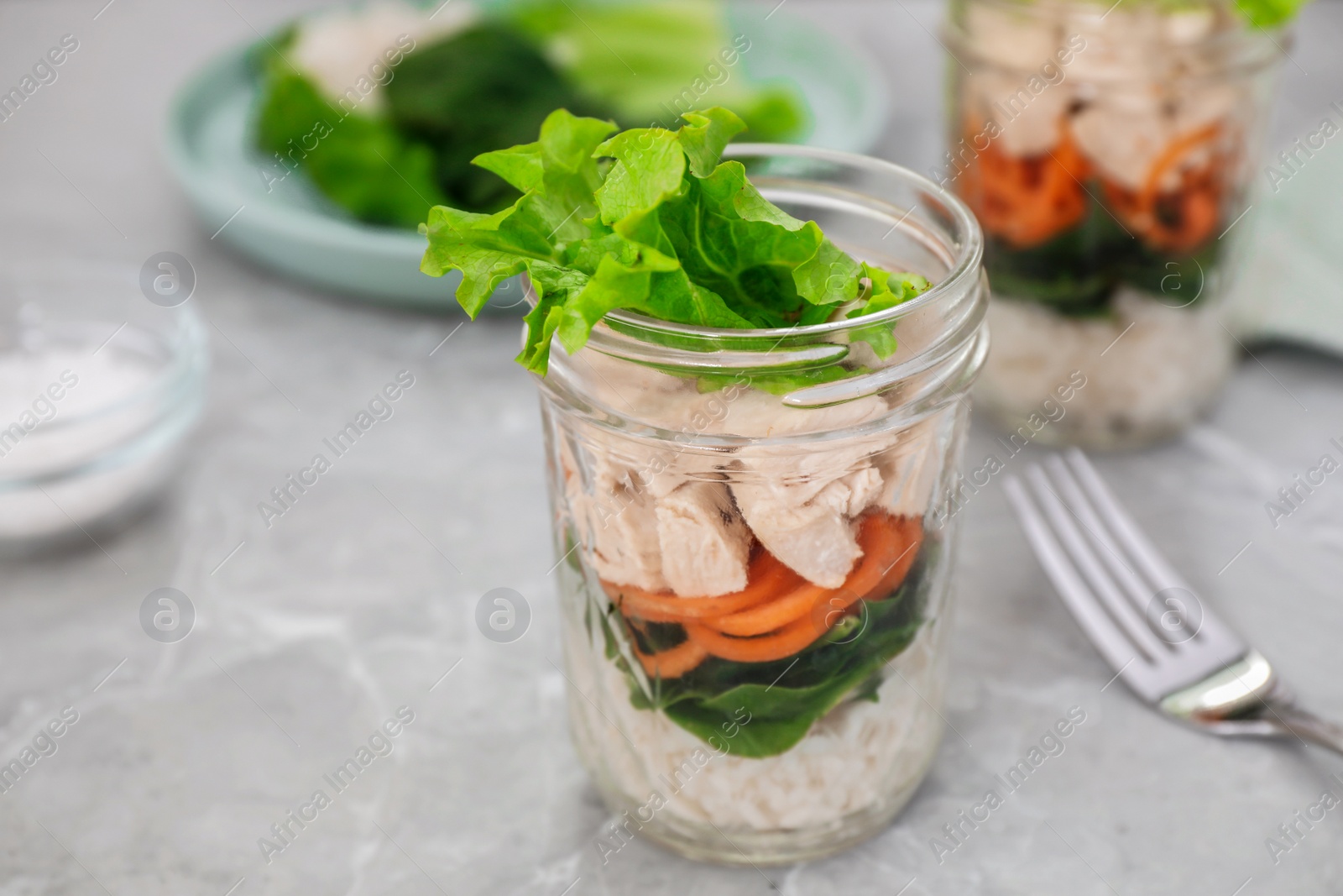 Photo of Healthy salad in glass jar on marble table