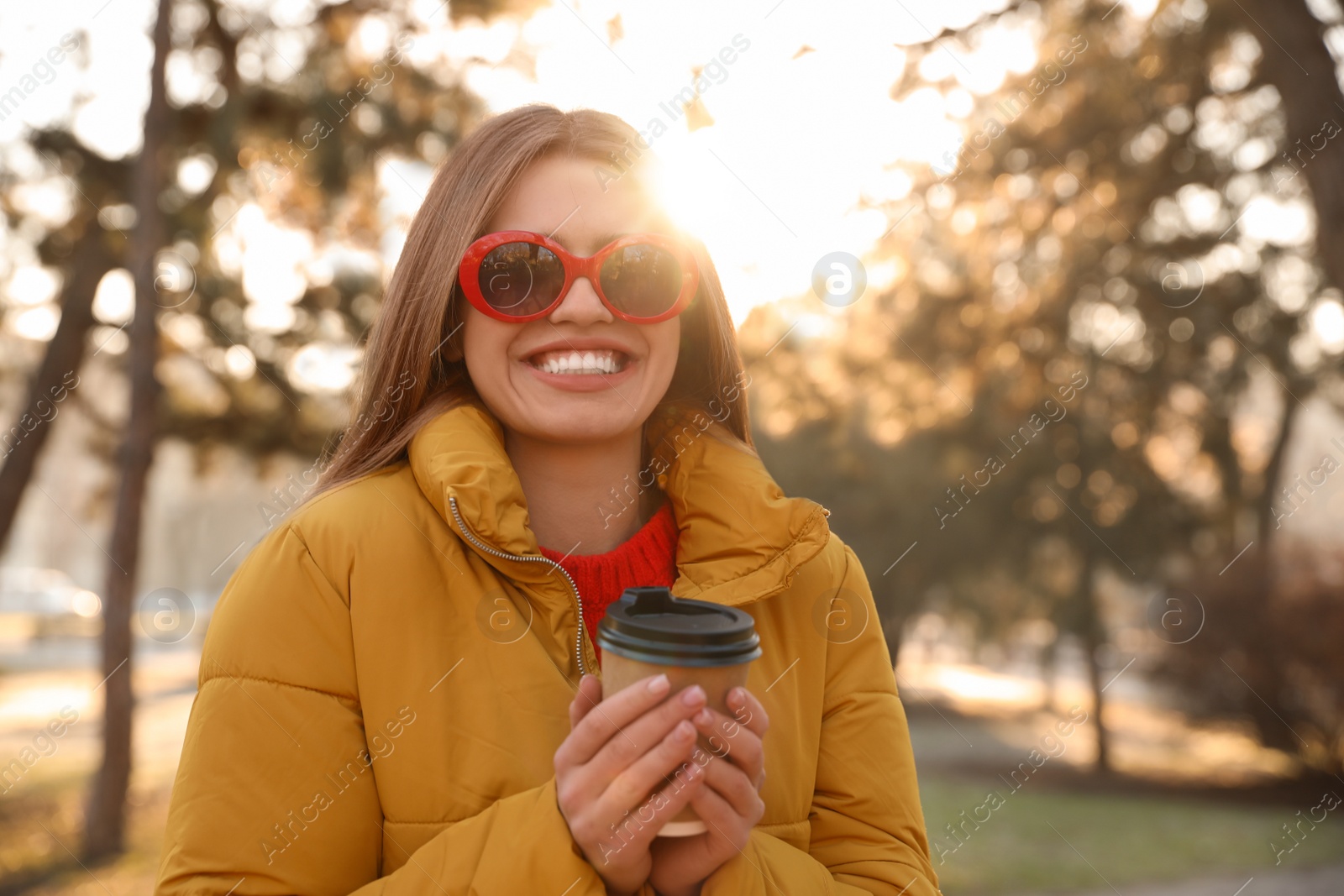 Photo of Young woman with cup of coffee in morning outdoors