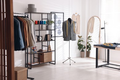 Tailor shop interior with mannequin and male suits on rack