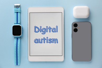 Photo of Tablet with phrase Digital Autism and devices on light blue background, flat lay. Addictive behavior