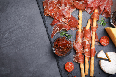 Photo of Tasty prosciutto served on grey table, flat lay. Space for text