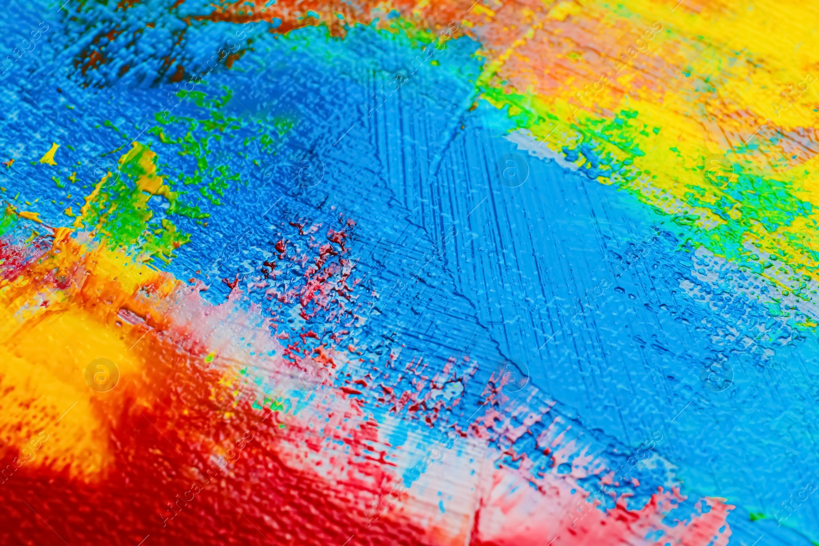 Photo of Strokes of colorful acrylic paints on canvas, closeup