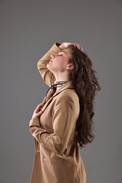 Portrait of beautiful young woman on grey background