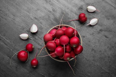 Bowl with fresh ripe radishes on grey table, flat lay