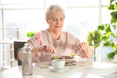 Photo of Elderly woman having breakfast at home