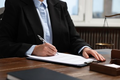 Photo of Lawyer working at wooden table in office, closeup