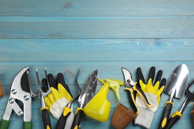 Photo of Flat lay composition with gardening tools on light blue wooden background, space for text