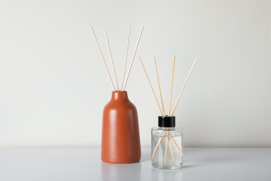 Aromatic reed air fresheners on white table