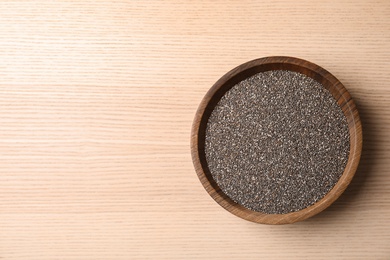 Photo of Bowl with chia seeds on wooden background, top view. Space for text