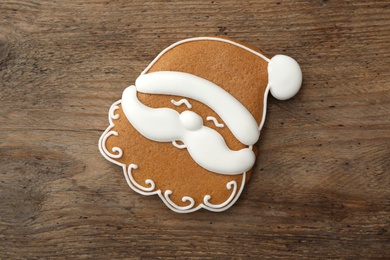 Santa Claus shaped Christmas cookie on wooden table, top view