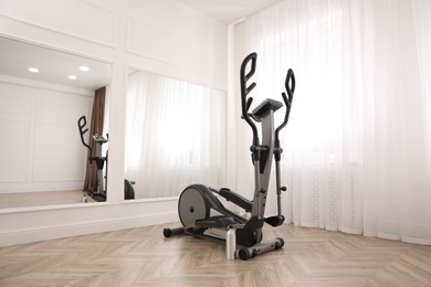 Elliptical machine cross trainer near mirror indoors