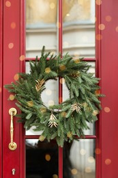 Beautiful Christmas wreath hanging on red glass door