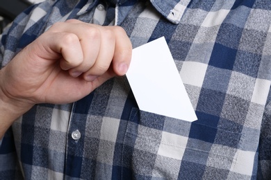 Photo of Man putting business card into pocket, closeup