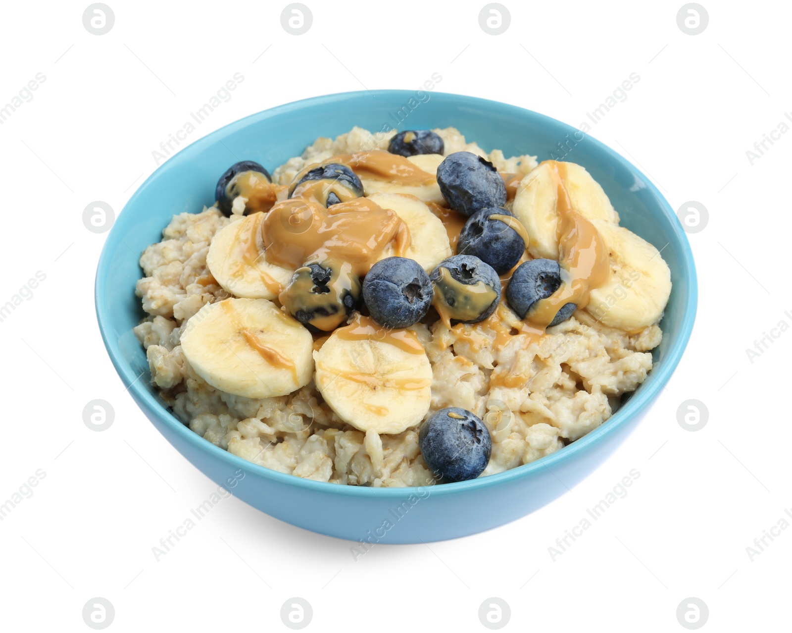 Photo of Tasty oatmeal with banana, blueberries and peanut butter in bowl isolated on white