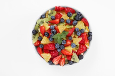 Photo of Yummy fruit salad in bowl on white background, top view