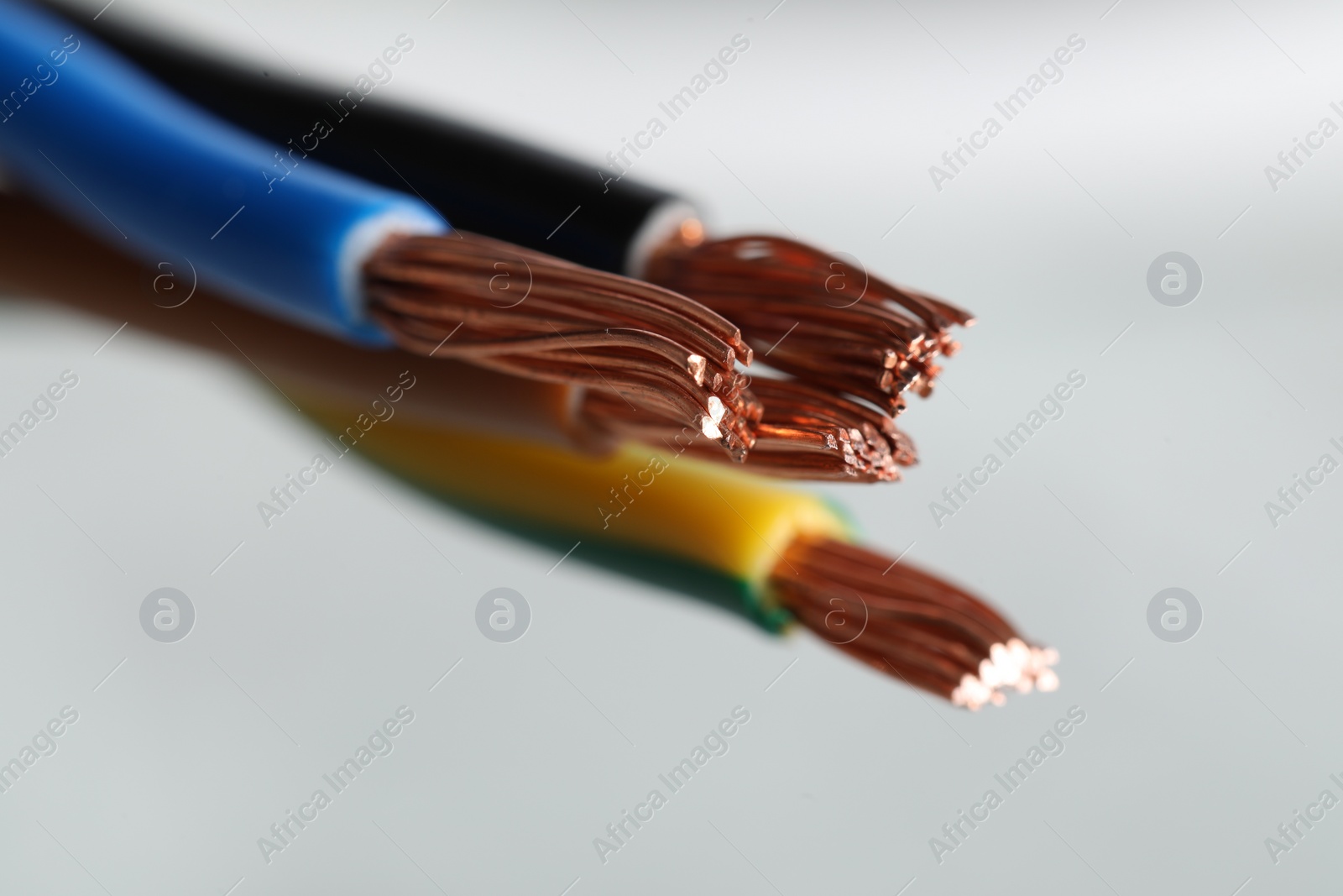 Photo of Colorful electrical wires on light background, closeup