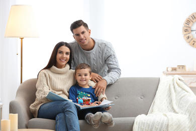 Photo of Happy family with little son reading book at home. Winter vacation