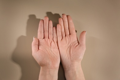 Woman showing palms on color background, top view. Chiromancy and foretelling