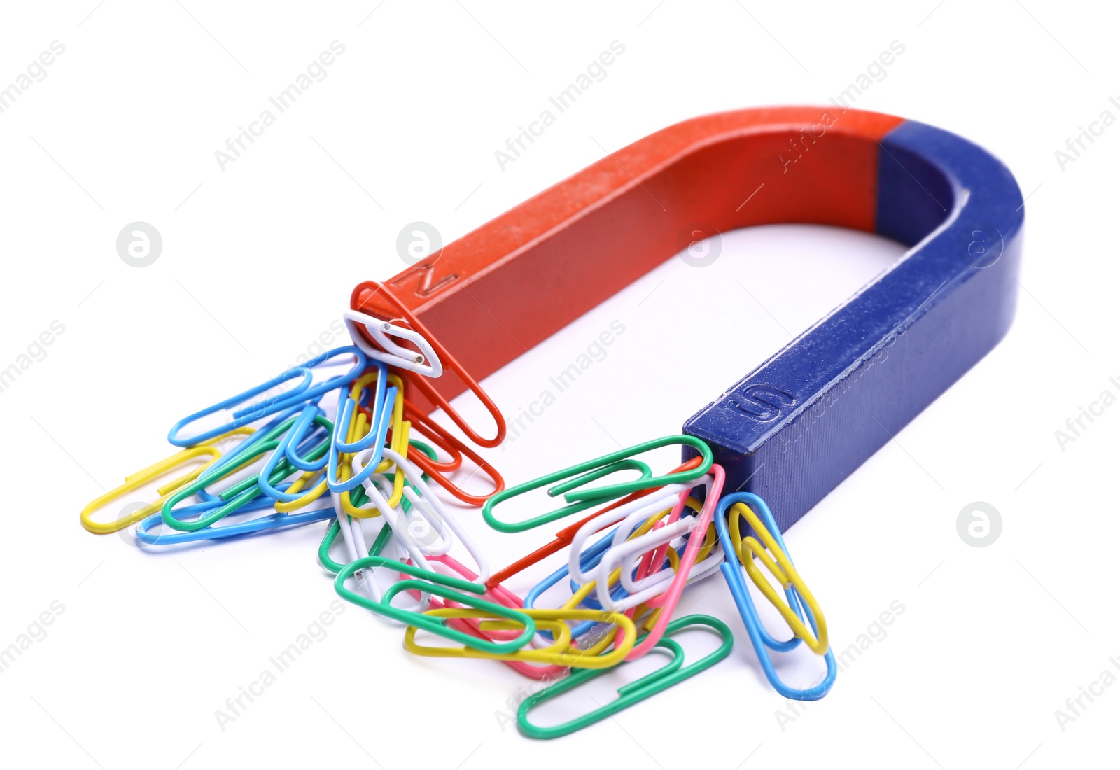 Photo of Horseshoe magnet attracting paper clips on white background