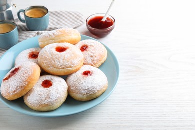 Delicious jam donuts served with coffee on white wooden table. Space for text