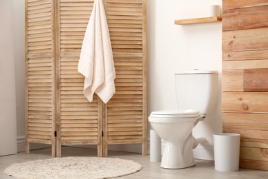 Photo of Toilet bowl near white wall in modern bathroom interior