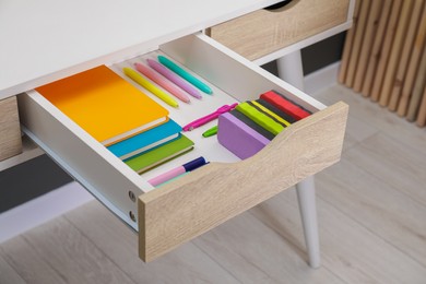 Photo of Office supplies in open desk drawer indoors