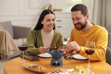 Affectionate couple enjoying chocolate fondue during romantic date at home