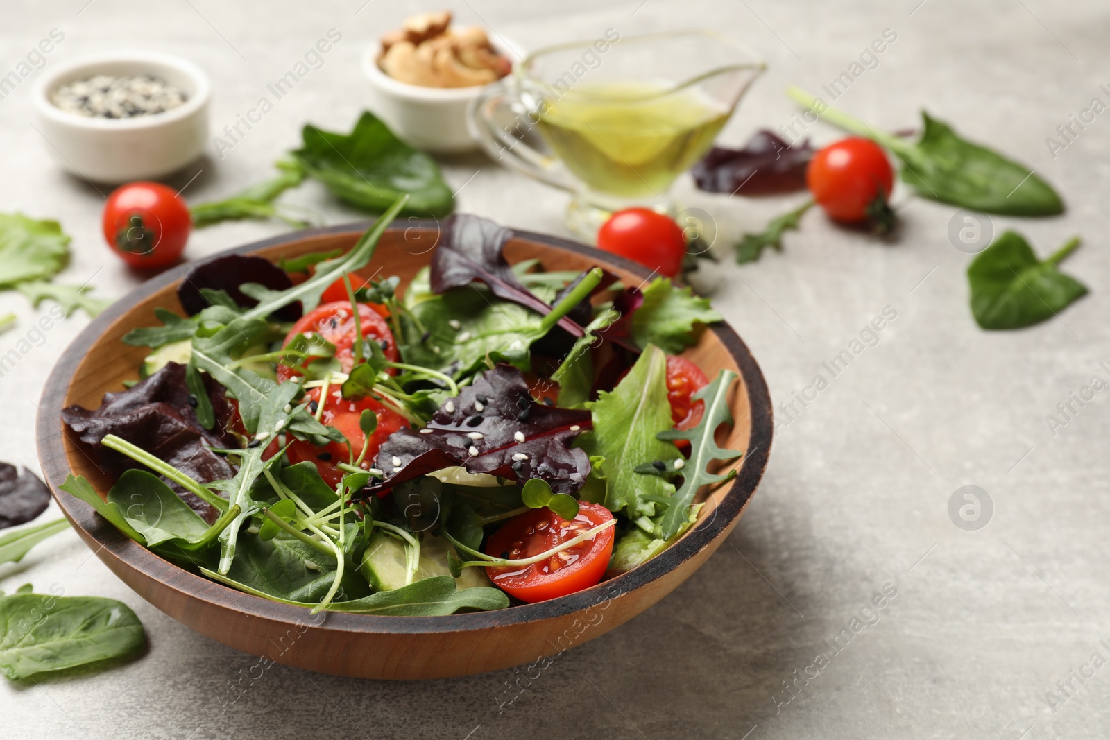 Photo of Tasty fresh vegetarian salad on grey table, space for text