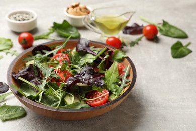 Tasty fresh vegetarian salad on grey table, space for text