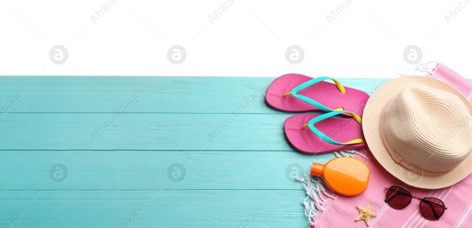 Photo of Beach accessories on light blue wooden table, flat lay. Space for text