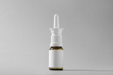 Bottle of nasal spray on grey background